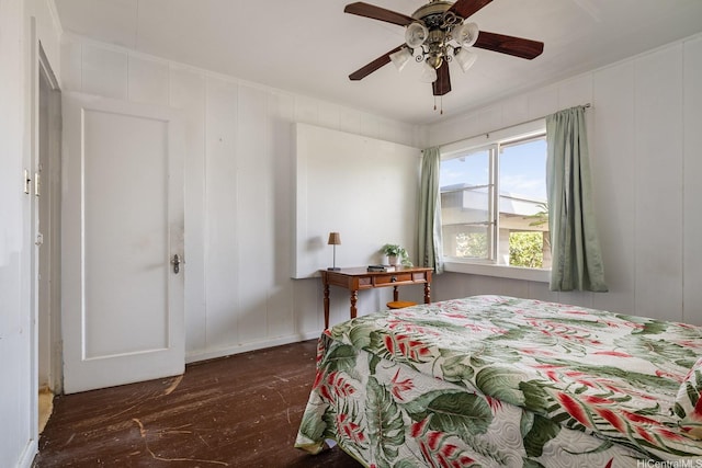 bedroom with a decorative wall, a ceiling fan, and hardwood / wood-style floors