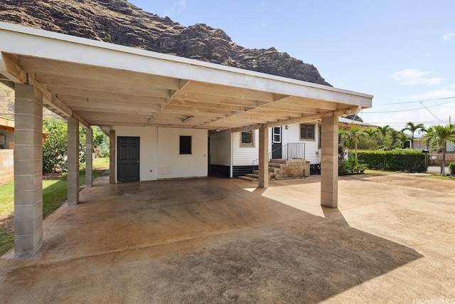 view of patio / terrace with driveway, a carport, and a mountain view