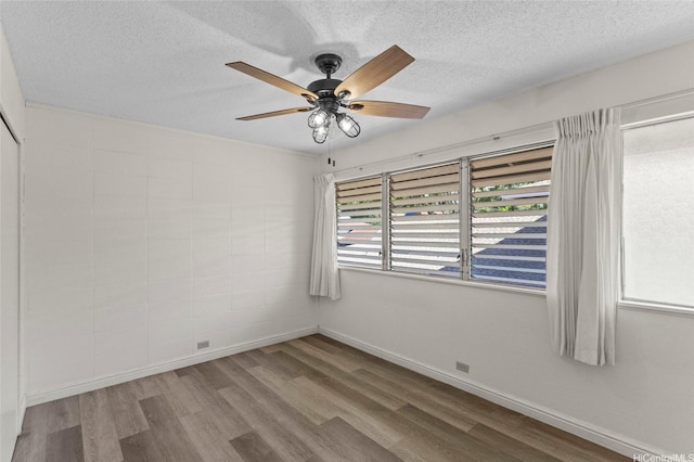 unfurnished room with wood finished floors, a textured ceiling, and ceiling fan