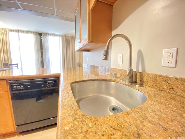 kitchen featuring a peninsula, a sink, glass insert cabinets, light stone countertops, and dishwasher