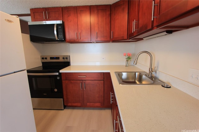 98-288 Kaonohi St Unit 3802, Aiea, HI 96701 - kitchen featuring appliances with stainless steel finishes, a sink, reddish brown cabinets, light countertops, and light wood-style floors
