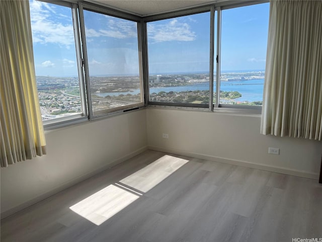 98-288 Kaonohi St Unit 3802, Aiea, HI 96701 - spare room featuring a water view, wood finished floors, and baseboards