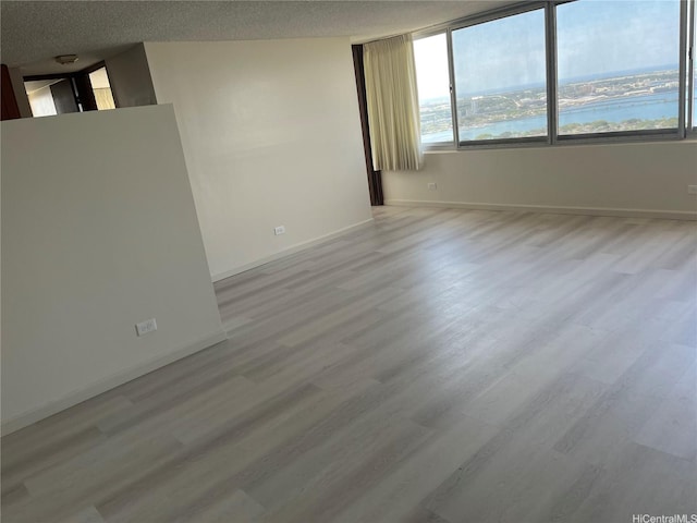 98-288 Kaonohi St Unit 3802, Aiea, HI 96701 - empty room with baseboards, light wood-style flooring, and a textured ceiling