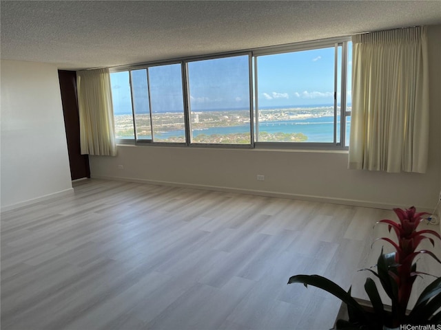98-288 Kaonohi St Unit 3802, Aiea, HI 96701 - spare room featuring a textured ceiling, a water view, and wood finished floors