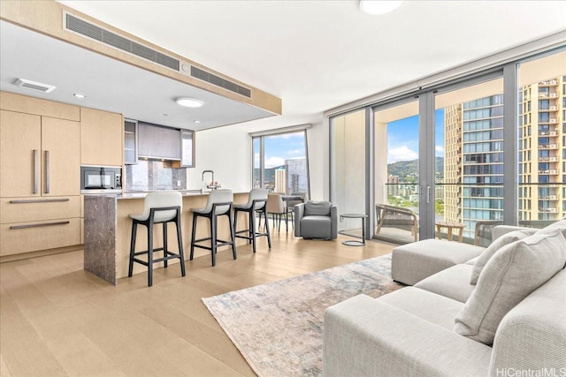 1000 Auahi St Unit 2410, Honolulu, HI 96814 - living area with light wood-style floors and a wall of windows