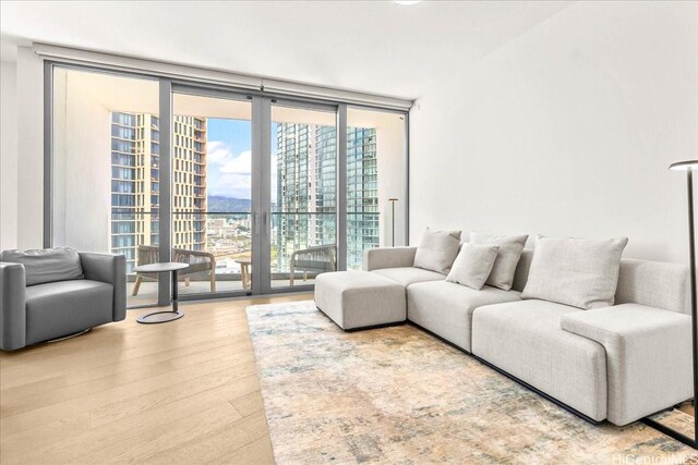 1000 Auahi St Unit 2410, Honolulu, HI 96814 - living room with a wall of windows and wood finished floors