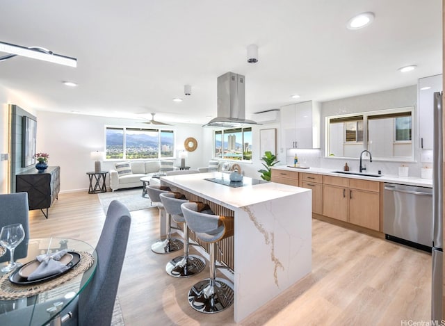1129 Ala Aloalo St, Honolulu, HI 96818 - kitchen featuring stainless steel dishwasher, island exhaust hood, a sink, a center island, and light wood-type flooring