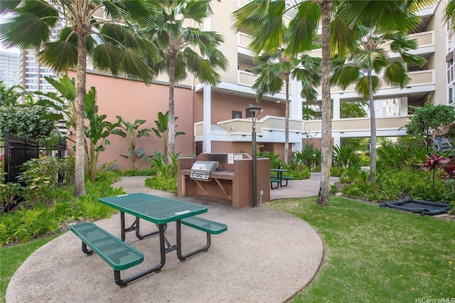 surrounding community with a lawn, a patio area, outdoor dining space, and area for grilling