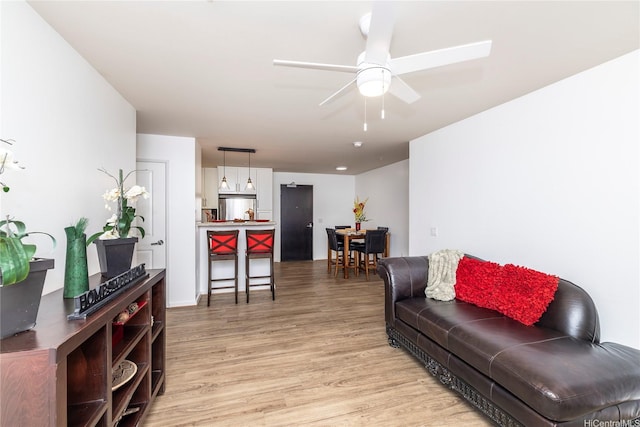 living room with light wood finished floors and a ceiling fan