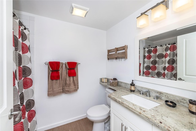 bathroom with toilet, wood finished floors, a shower with curtain, baseboards, and vanity