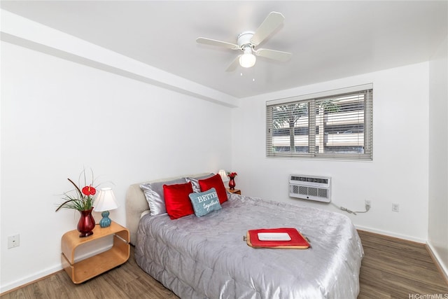 bedroom with baseboards, a wall unit AC, a ceiling fan, and wood finished floors