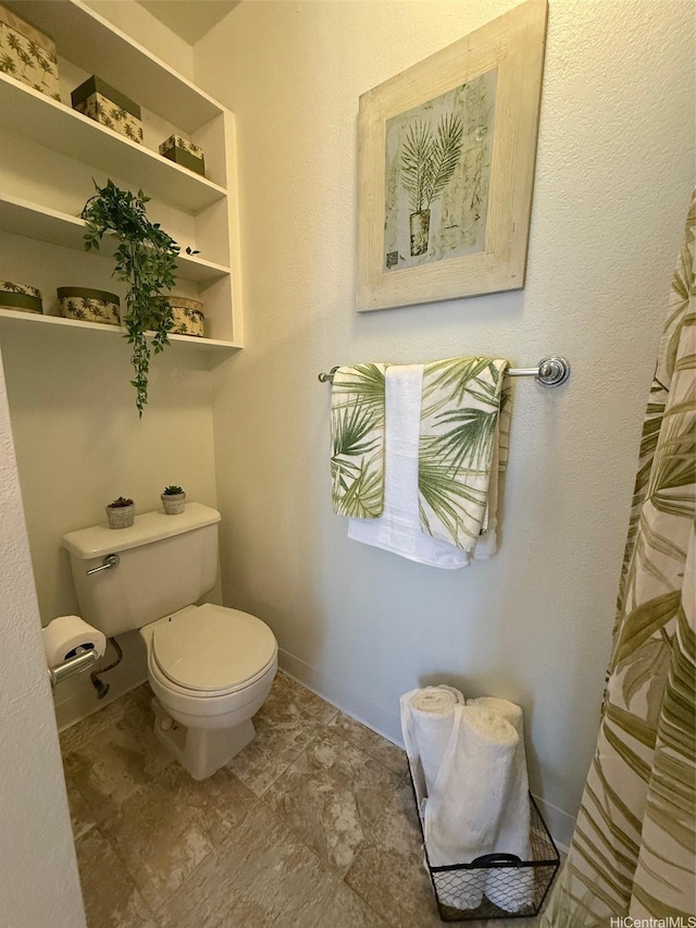 bathroom with toilet and baseboards
