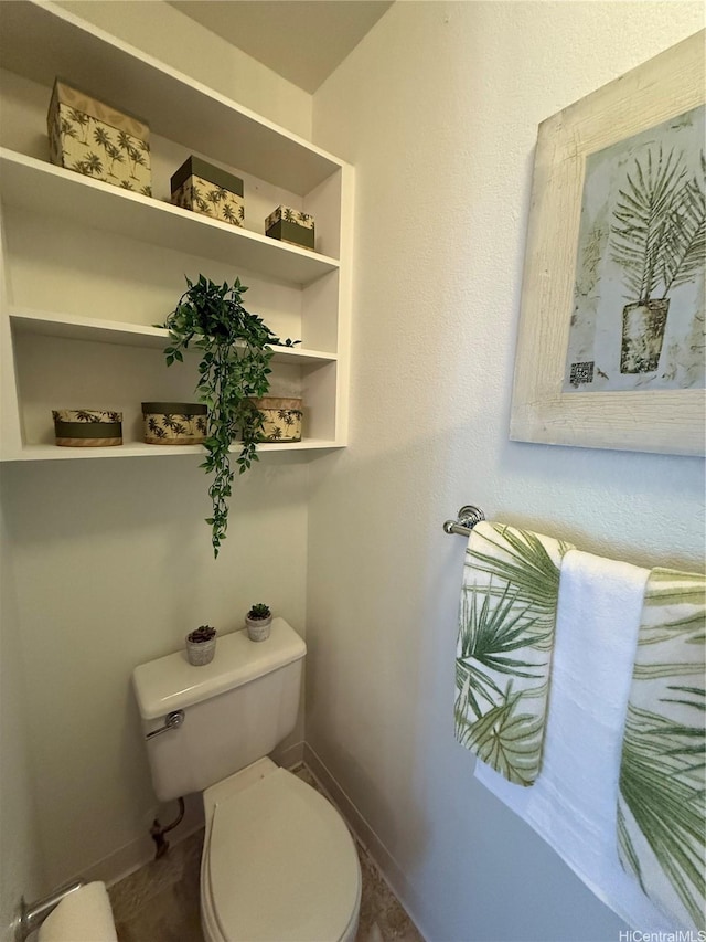 bathroom with baseboards and toilet
