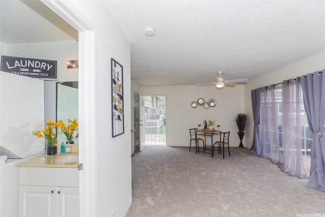 interior space featuring a textured ceiling, light carpet, and a sink