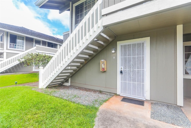 entrance to property featuring a lawn