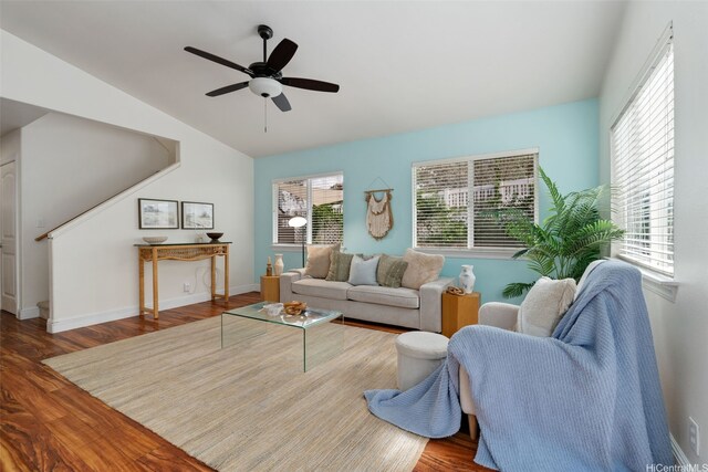 living area with ceiling fan, lofted ceiling, wood finished floors, and baseboards