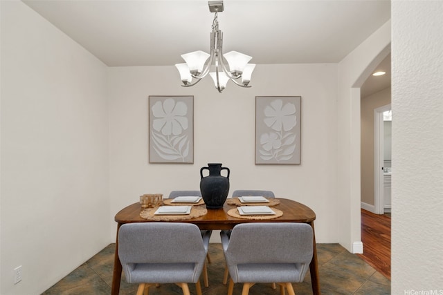 dining area with recessed lighting, arched walkways, and a notable chandelier