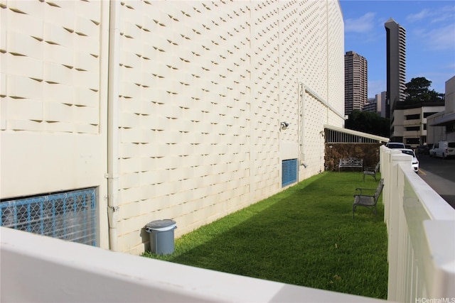 view of side of property with a yard and a view of city