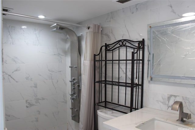 full bath with toilet, a shower with curtain, vanity, and visible vents