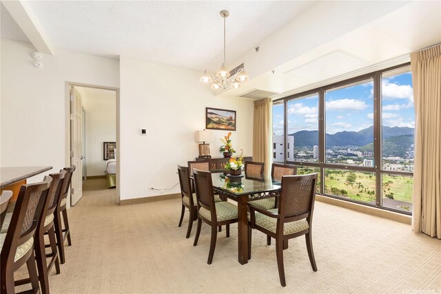 229 Paoakalani Ave Unit 3801, Honolulu, HI 96815 - dining space with a mountain view, baseboards, a chandelier, light colored carpet, and a wall of windows