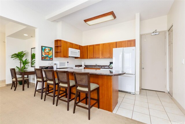 229 Paoakalani Ave Unit 3801, Honolulu, HI 96815 - kitchen featuring a sink, white appliances, open shelves, brown cabinetry, and a breakfast bar area