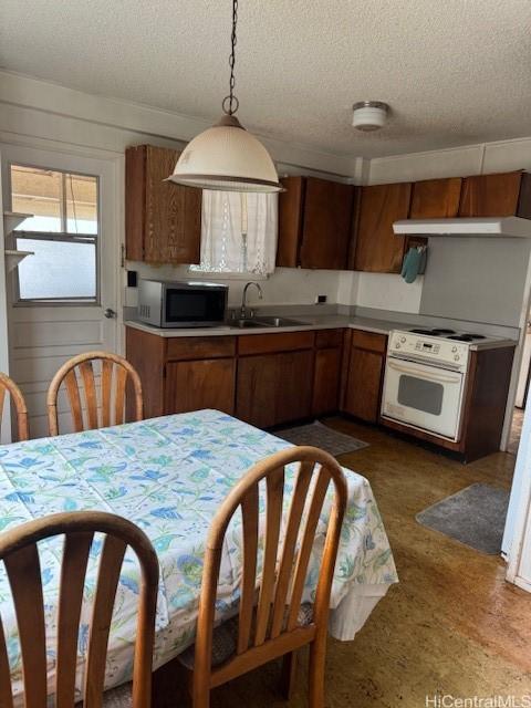 94-440 Kiau Pl, Waipahu, HI 96797 - kitchen with stainless steel microwave, brown cabinets, a sink, and a textured ceiling
