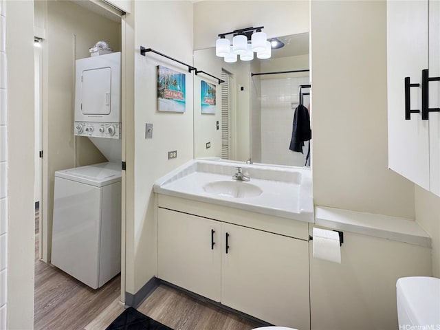 bathroom with wood finished floors, vanity, and stacked washer / dryer