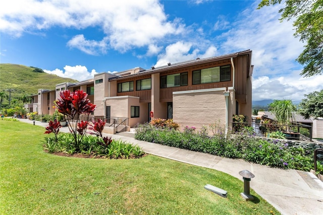 411 Kaelepulu Dr Unit E, Kailua, HI 96734 - view of front of house featuring a front yard, stucco siding, and a mountain view