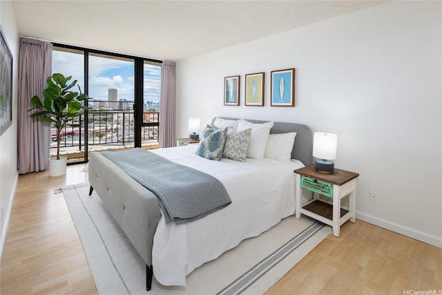 3138 Waialae Ave Unit 918, Honolulu, HI 96816 - bedroom featuring light wood-style flooring, access to outside, expansive windows, and baseboards