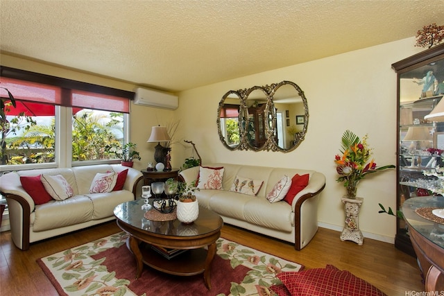 living room featuring wood finished floors, a wall mounted AC, and a textured ceiling