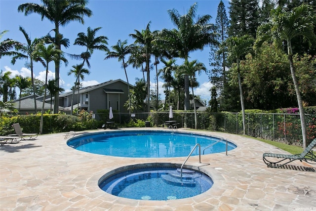 pool featuring fence, a patio area, and a hot tub