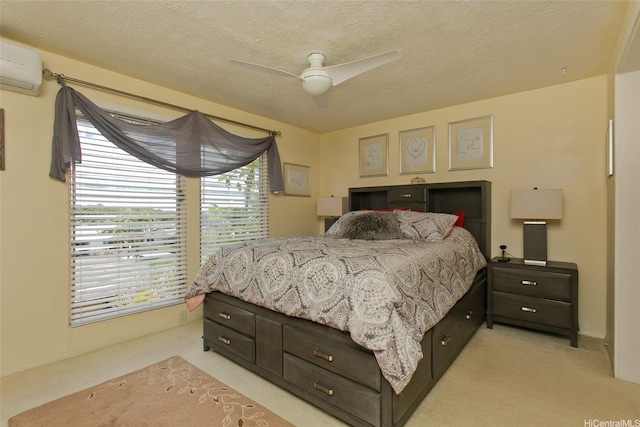 bedroom featuring light carpet, a ceiling fan, an AC wall unit, and a textured ceiling