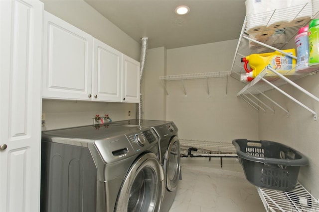 clothes washing area featuring washer and dryer, cabinet space, marble finish floor, and recessed lighting