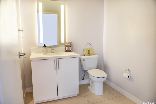 bathroom with toilet, vanity, tile patterned floors, and baseboards