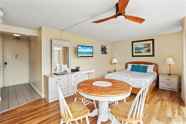 2427 Kuhio Ave Unit 2205, Honolulu, HI 96815 - bedroom with light wood finished floors, a ceiling fan, baseboards, and a textured ceiling