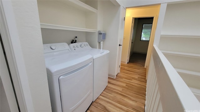 laundry room with washer and clothes dryer, light wood-style floors, and laundry area