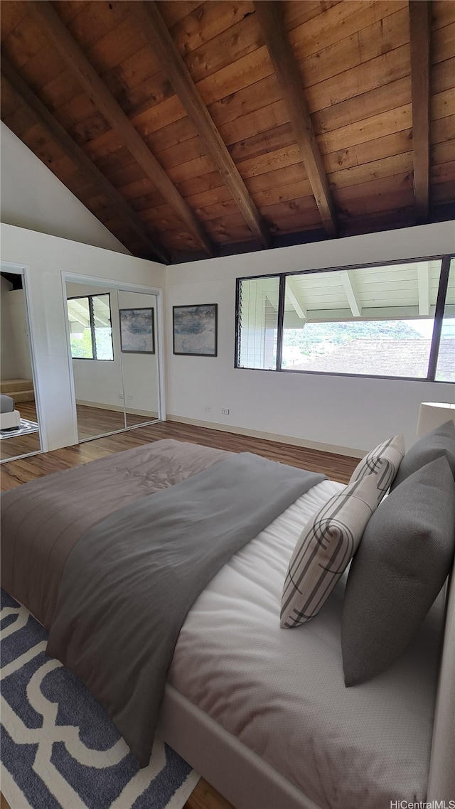 bedroom with wood ceiling, lofted ceiling with beams, wood finished floors, and two closets