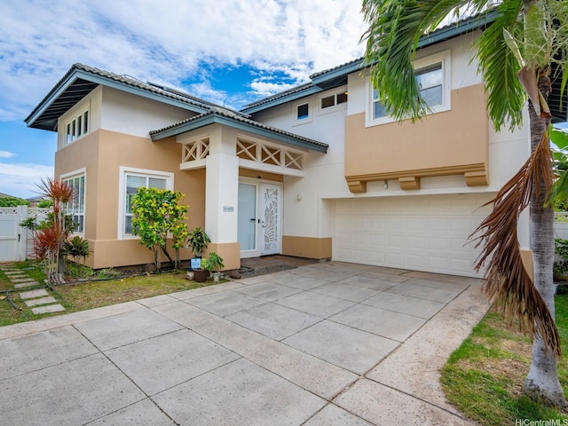 view of front of home featuring a garage, a tile roof, concrete driveway, and stucco siding