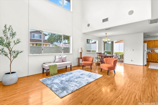 94-513 Kaikua Pl, Waipahu, HI 96797 - living room featuring an inviting chandelier, a high ceiling, light wood-style flooring, and visible vents