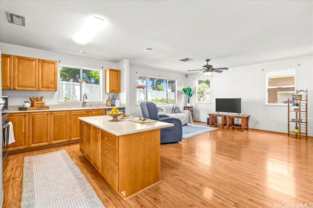 94-513 Kaikua Pl, Waipahu, HI 96797 - kitchen with a ceiling fan, a center island, a sink, light countertops, and light wood-style floors