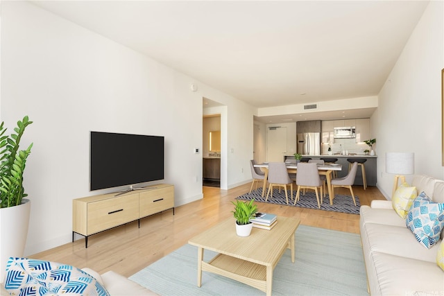 living area with visible vents and light wood-style floors