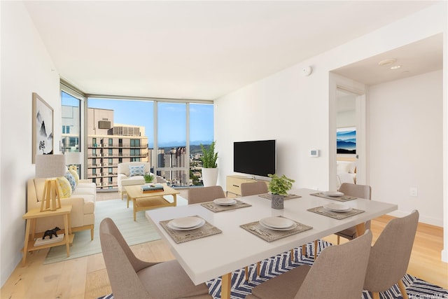 dining space featuring light wood-style floors and a wall of windows