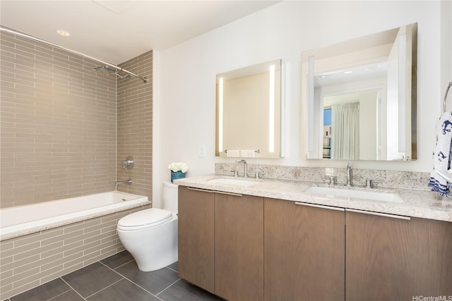 full bathroom featuring toilet, tile patterned flooring, a sink, and tiled shower / bath