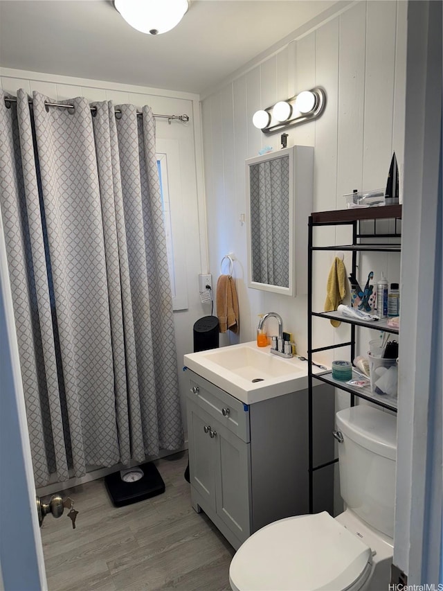 full bathroom featuring wood finished floors, toilet, a shower with shower curtain, and vanity