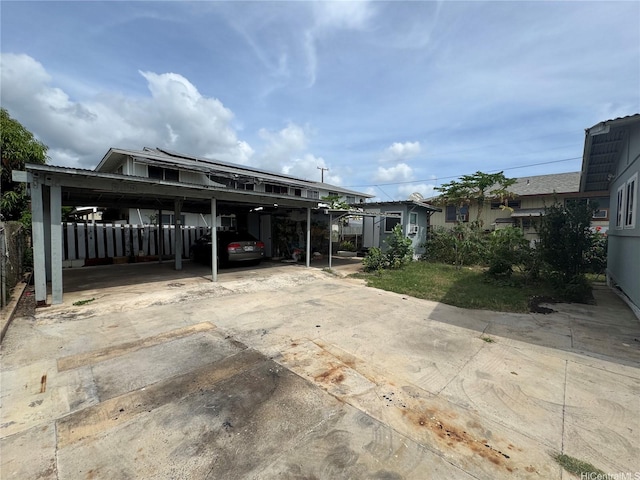 view of car parking with fence and concrete driveway