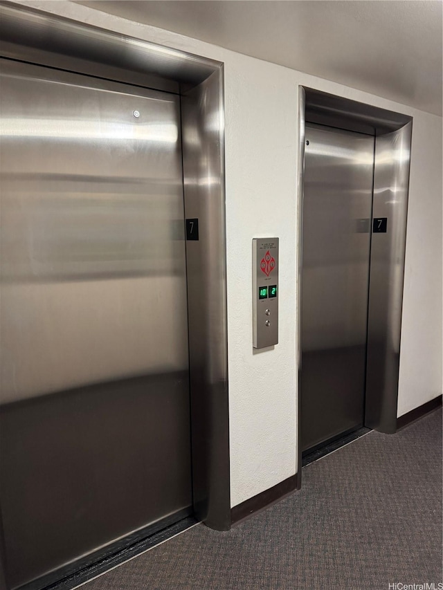 interior details with elevator, carpet flooring, and baseboards