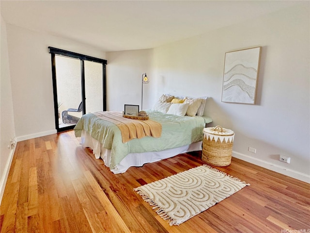 555 Hahaione St Unit 10F, Honolulu, HI 96825 - bedroom with baseboards, access to outside, and wood finished floors