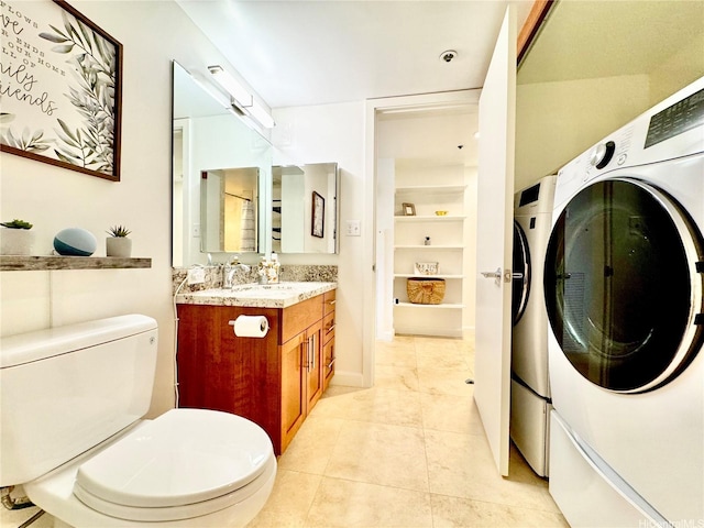 555 Hahaione St Unit 10F, Honolulu, HI 96825 - bathroom with washing machine and dryer, toilet, vanity, and tile patterned floors