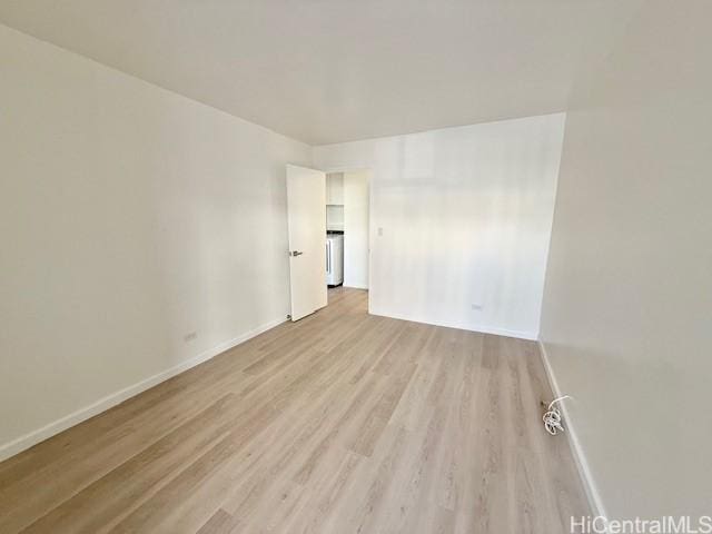 spare room featuring light wood-style floors and baseboards