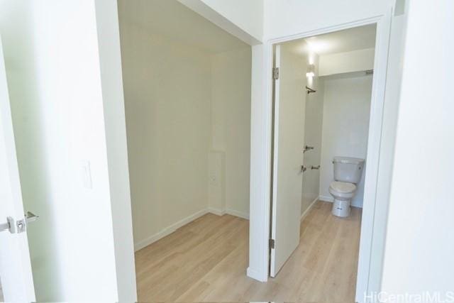 bathroom with toilet, wood finished floors, and baseboards